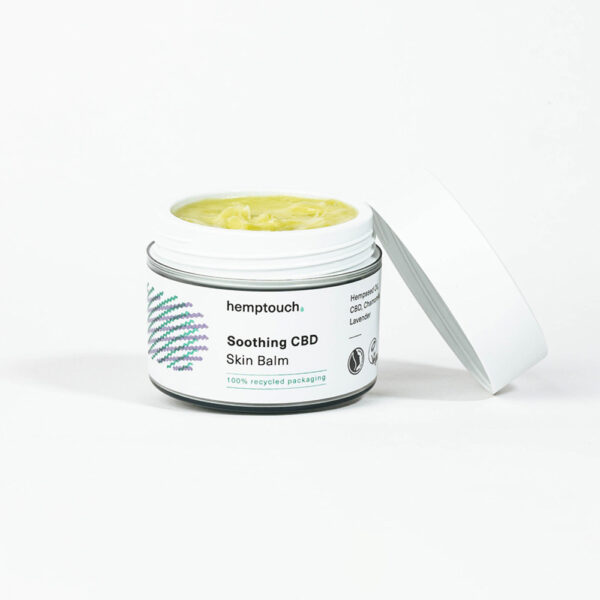 En krukke med Hemptouch CBD salve til irriteret hud (50ml/50mg) med låget let åbent, som viser den lysegule balsam indeni. Mærket fremhæver hamp og genbrugsemballage.